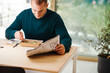 © Melissa Milis Photography/Stocksy - Man enjoying his food while reading newspaper