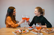 © Ligia - Radiant smiles of two girls having a toast over brunch.