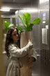 © Demetr White/Stocksy - girl rides in an elevator with a flowerpot