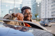© Jovo Jovanovic/Stocksy - Smiling man in glasses leaning on car roof in city