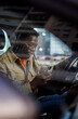 © Jovo Jovanovic/Stocksy - Young man text messaging using mobile phone sitting in car