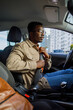 © Jovo Jovanovic/Stocksy - Man paying attention to road holding buckled driver seat belt of car