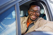 © Jovo Jovanovic/Stocksy - Happy man in car looking at camera through open window and smiling