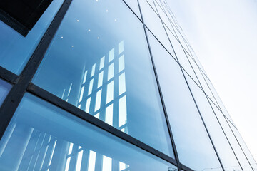 Canvas Print - the blue sky is reflected in the windows of a modern office building. architecture and exterior of c