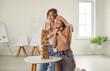 Teenage child having play therapy with their loving mother or friendly psychologist. Happy, smiling girl and a young woman hugging by a table with a wooden tower game. Children's psychology concept