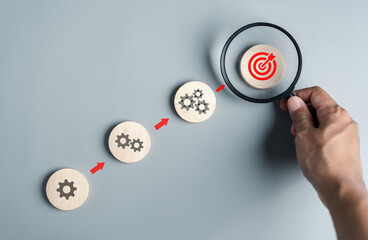 Leinwandbilder - Hand holding magnifier to analysis target objective pointing management, Steps planning development and business concept.