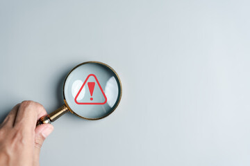system warning caution sign inside magnifier for notification error and maintenance. cyber attack on