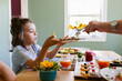 © ByLorena/Stocksy - Boy getting served scrambled eggs at styled table