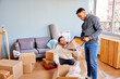 © ALTO IMAGES/Stocksy - Smiling multiracial men in casual clothes unpacking picture