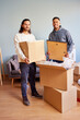 © ALTO IMAGES/Stocksy - Positive multiracial males in casual clothes carrying cardboard boxes