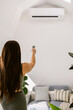 © ByLorena/Stocksy - Woman turns on air conditioner in yoga studio
