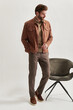 © Elena Kharichkina/Stocksy - Fashion portrait of a stylish man in full growth on a light background
