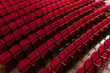 © Ezequiel Giménez/Stocksy - Red rows of bright empty seats in theater