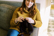 © Serena Burroughs/Stocksy - happy relaxed woman sitting on sofa in her home and knitting