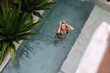 © Mihajlo Ckovric/Stocksy - Top view image of a woman in swimming pool