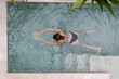 © Mihajlo Ckovric/Stocksy - Overhead view of a woman in swimming pool