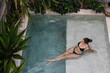 © Mihajlo Ckovric/Stocksy - Top angle view of a woman sitting in a swimming pool
