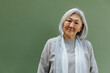 © Stereo Shot/Stocksy - Positive elderly woman on green background