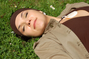 Poster - attractive woman relaxing on green grass