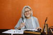 © Stereo Shot/Stocksy - Senior woman practicing calligraphy