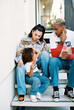 © Jenna Elliott/Stocksy - Family Sit on Front Steps