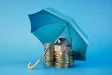 Insurance When Renting And Buying A Home. Coins And A House Under An Umbrella. 3D Render