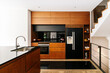 © Nibuya Qubik/Stocksy - Modern minimalistic black and wooden design kitchen