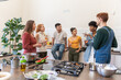© Luis Velasco/Stocksy - Diverse Friends Chatting And Having A Glass Of Wine In The Kitchen.