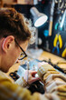 © Daniel Gonzalez/Stocksy - Repairman troubleshooting amplifier in repair shop