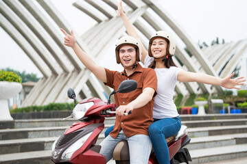 Wall Mural - Young Asian couple on the motorbike