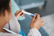 © Adene S/peopleimages.com - Pregnancy test, woman hands and waiting at home for results on a living room couch. House, female person and hand with medical and fertility testing stick to show pregnant sign alone on lounge sofa