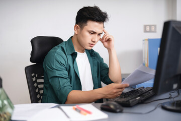 Wall Mural - Photo of young Asian businessman working at office