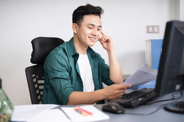 Wall Mural - Photo of young Asian businessman working at office