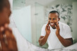 © Stratford/peopleimages.com - Happy, morning and mirror with black man in bathroom for beauty, skincare and grooming. Cleaning, hygiene and self care with reflection of male person at home for facial, natural and wellness