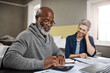 © K Seisa/peopleimages.com - Calculator, documents or finance with an old couple busy on a budget review in the home together. Accounting, taxes or investment with a senior man and interracial woman planning insurance or savings
