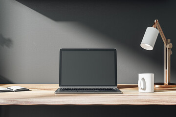 Front view on blank dark modern laptop monitor with place for web design, website or landing page on wooden work table with coffee mug and sunlit black wall background. 3D rendering, mock up