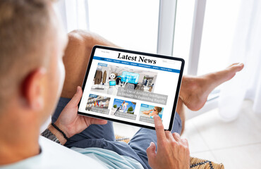 Wall Mural - man reading news website on digital tablet