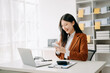 © Nuttapong punna - Asian businesswoman working in the office with working notepad, tablet and laptop documents in office