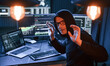 © standret - Got caught. With hands up. Male professional hacker is sitting by computer, conception of virus