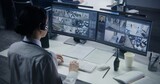 Fototapeta  - Security officer in headset controls CCTV cameras with AI facial recognition on PC. Female employee works in security control center. Computer monitors showing surveillance cameras video footage.