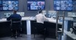 © Framestock - Diverse team of officers watch CCTV cameras with AI facial recognition. Employees work in security control center. Computer monitors and big digital screens showing surveillance cameras video footage.