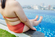 © Charlie's - Overweight young asian woman wearing swimsuit relaxing in the pool Happy plus size woman cheery funny Vacation Traveling in summer.