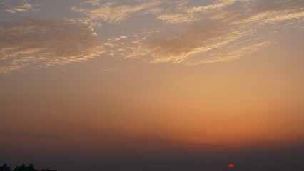 Wall Mural - the beautiful sunset view with the buildings' silhouette and orange color sky as background in the c