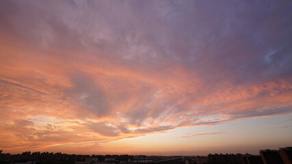 Wall Mural - the beautiful sunset view with the buildings' silhouette and orange color sky as background in the c
