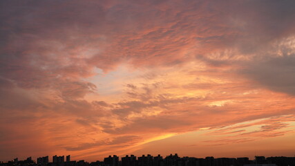 Wall Mural - the beautiful sunset view with the buildings' silhouette and orange color sky as background in the c