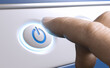 © Olivier Le Moal - Finger pressing a power button to start an electronic device.