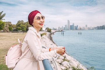 Wall Mural - With the radiant sun shining down on her, an Indian girl proudly wears her turban as she takes a peaceful walk along the Abu Dhabi embankment, enjoying the natural beauty and tranquility of the city.