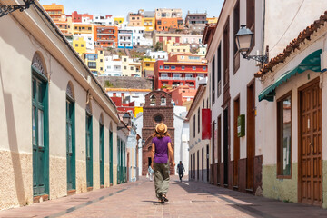 Lifestyle, woman on vacation walking through the city of San Sebastian de la Gomera next to the Iglesia De La Asuncion, Canary Islands