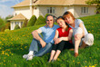 © Designpics - Portrait of a happy family of three on the lawn on front of their house