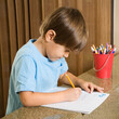 © Designpics - Side view of Hispanic boy concentrating on homework.